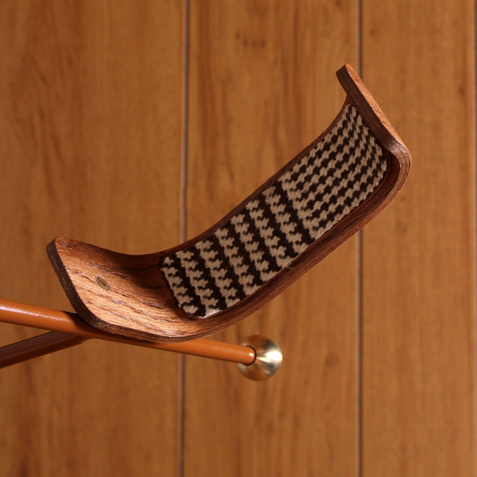 VHS Edition Guitar Stand with cream base and stained oak rests with houndstooth tweed, shown next to a vintage CRT TV and wood paneling.