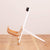 A sideview of a white guitar stand with wooden guitar body rests 
