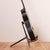 A Black guitar stand with wooden guitar body rests 