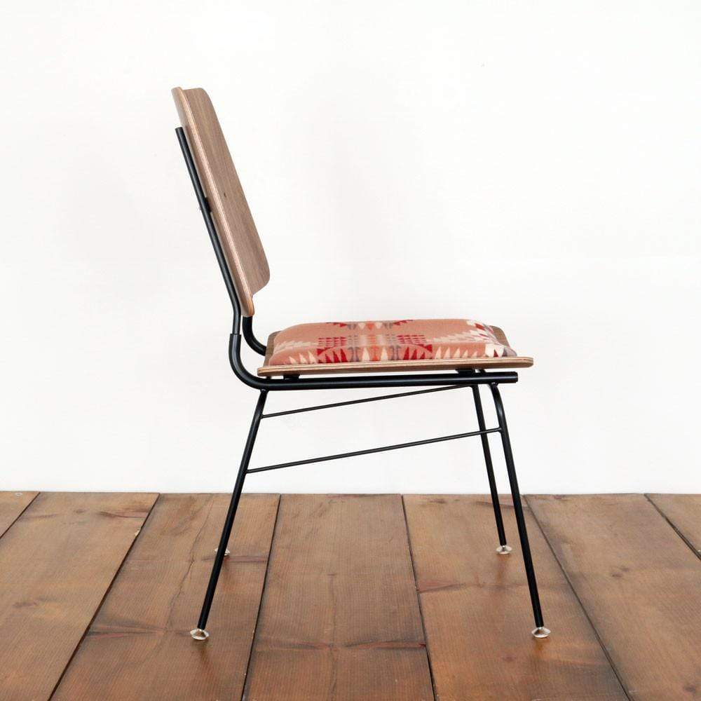 Side view of a molded plywood chair with a pendelton seat cushion